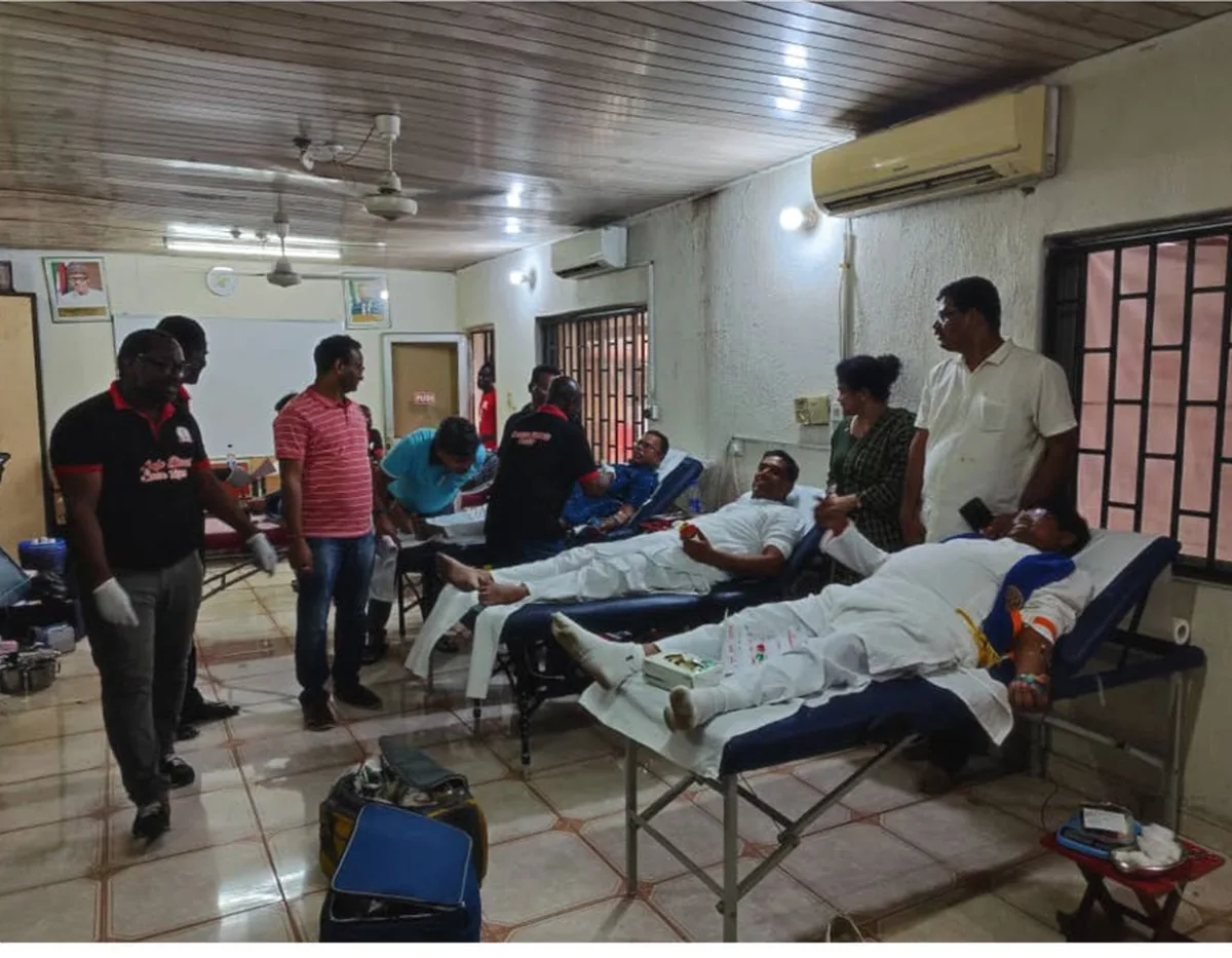 Donors on couches at a club blood donation camp, with Rotary volunteers in branded shirts attending them.