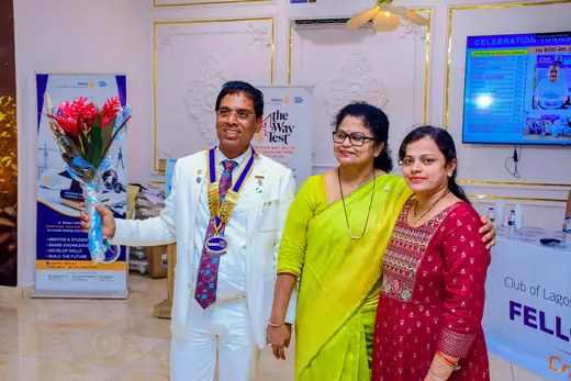 The club president presenting flowers to two members at the fellowship.