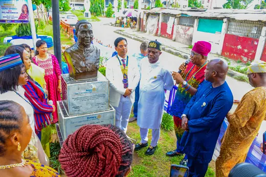 Members and guests pressed in around the bust during the rededication.